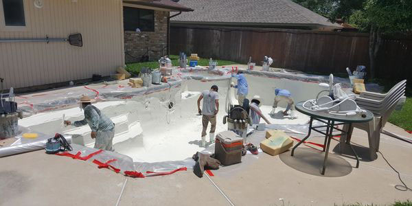 Integrity Pools crew resurfacing a residential backyard pool in Dallas–Fort Worth